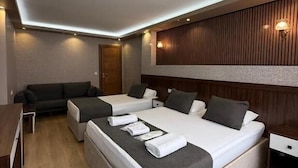 Una habitación de hotel moderna con una cama grande, un sofá y un escritorio.