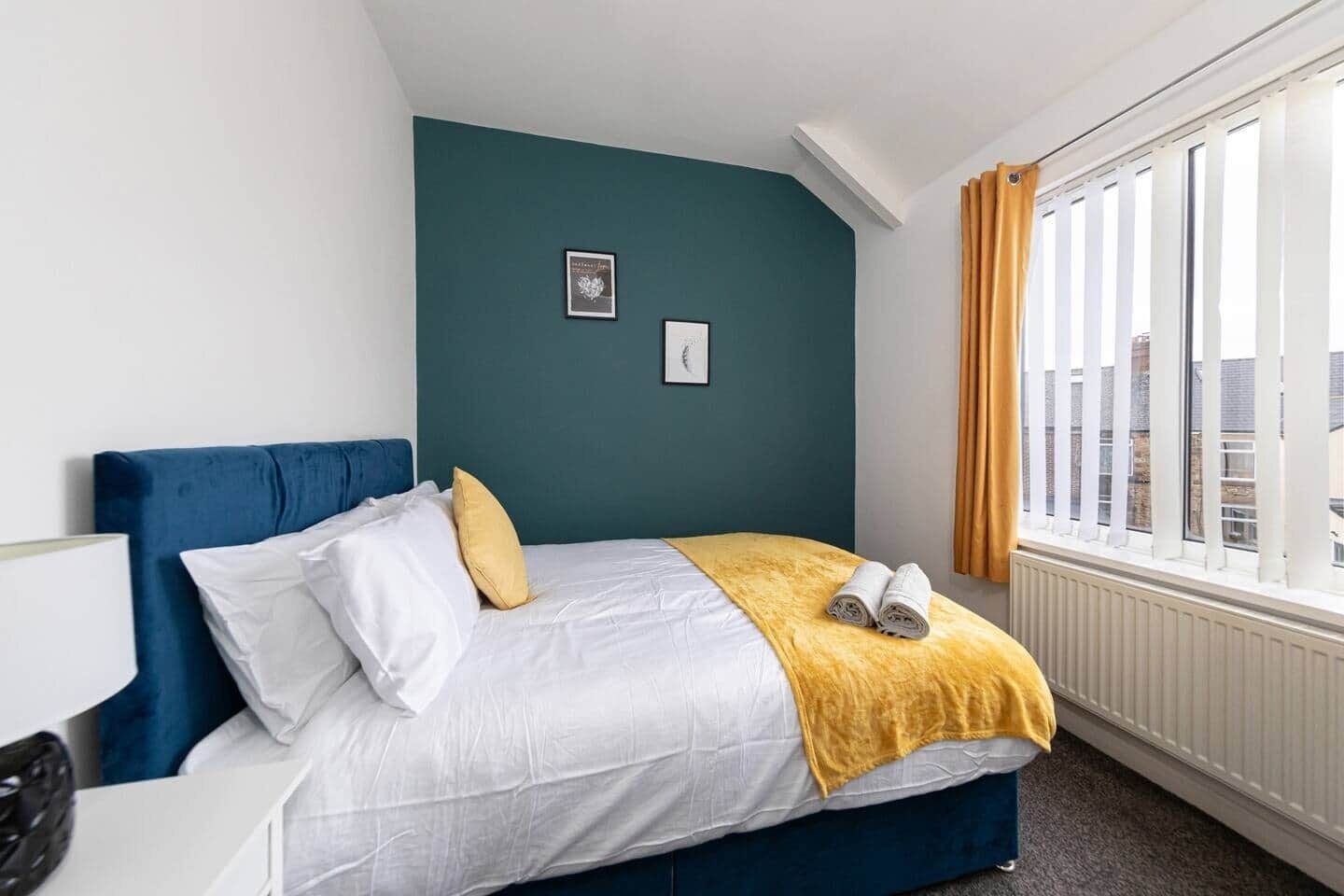 Une chambre d’hôtel avec un lit, une fenêtre avec des rideaux et une vue sur les bâtiments environnants.