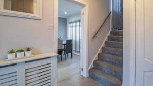 A staircase leading to a dining area with a table and chairs. - Catriona House - 3 Bedroom house in Motherwell (Holytown)