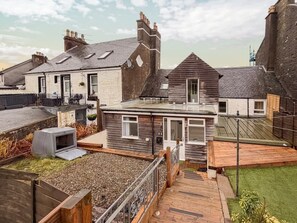 A residential property with a wooden deck, a small garden, and a visible satellite dish.