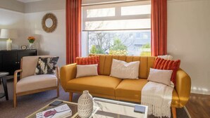 A living room with a sofa, armchair, and a coffee table.