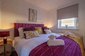 A hotel room with a bed, a window, a painting on the wall, and a lamp. - The Bridge- 3 Bedrooms in Coatbridge with Driveway (Coatbridge)