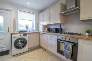 Una cocina moderna con lavadora, horno y cocina a gas.