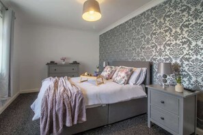Une chambre à coucher avec un lit, une table de chevet et une commode.
