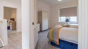 A bedroom with a bed, a window, and a wardrobe. - William Wallace View - 5 Bedroom House Near Castle (Stirling)