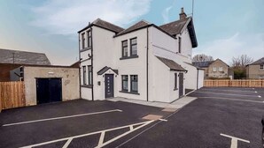 A two-story residential building with a garage, a driveway, and a parking area. - William Wallace View - 5 Bedroom House Near Castle (Stirling)