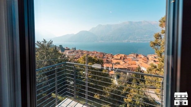 A balcony with a view of a coastal town and mountains. - Enjoy a relaxing stay in this cozy apartment located just above the Bellano hill. The elevated position offers splendid views of Lake Como, perfect for unforgettable sunsets. The apartment includes a private parking space and all the amenities for a peac (Bellano)