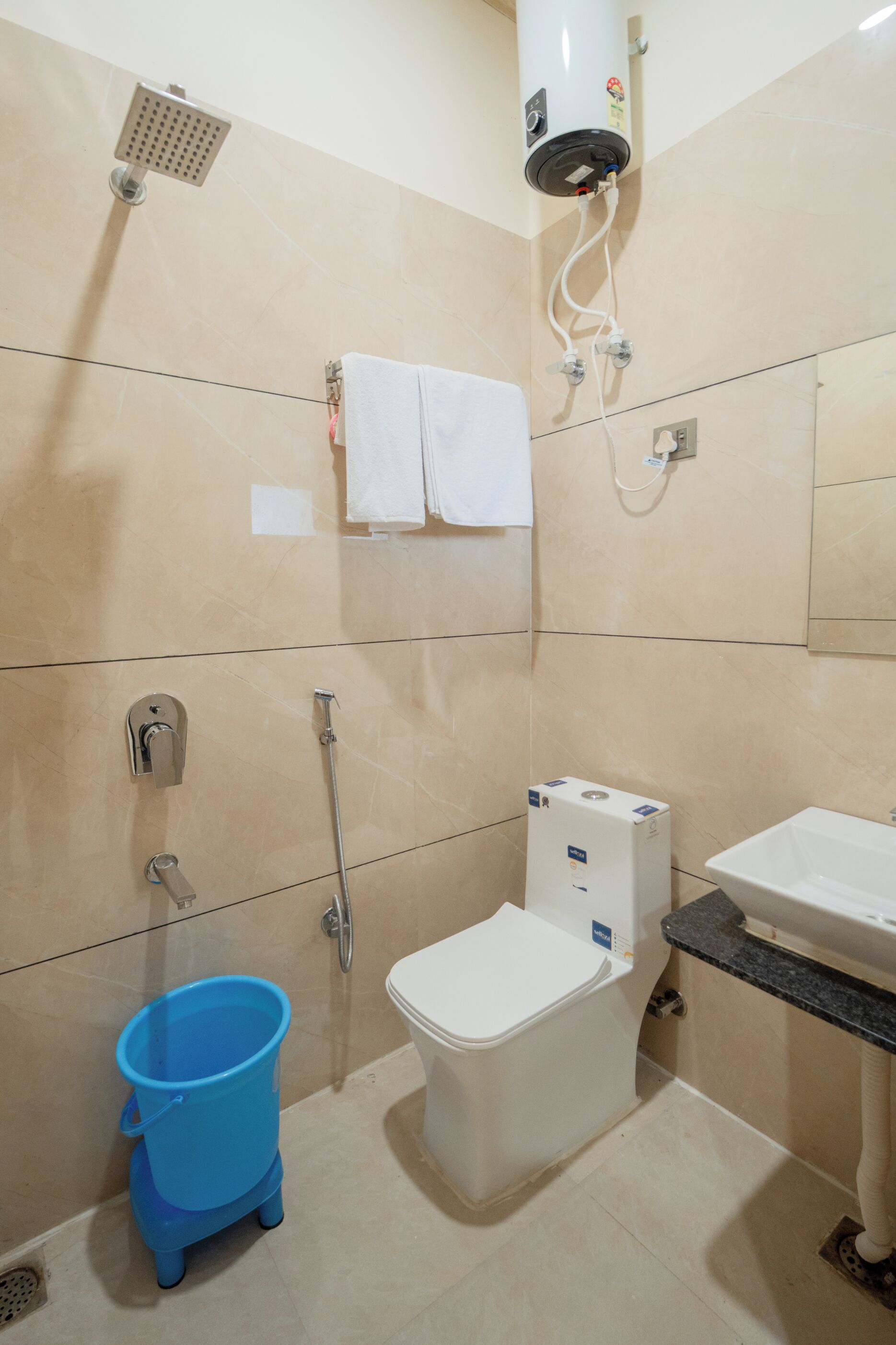 A bathroom with a toilet, bidet, shower, and sink.