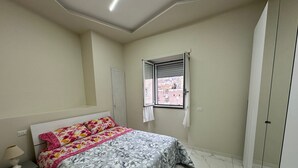 Une chambre à coucher comprenant un lit, une table de chevet, une fenêtre avec vue et une armoire.