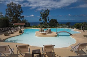 A pool with lounge chairs, a fire feature, and a view of the ocean. - Miramare Castellabate Resort (Castellabate)
