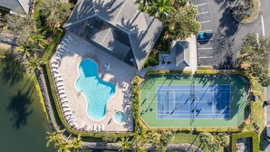 Ein Luftbild eines Resorts mit Schwimmbad, Tennisplätzen und Parkplatz.