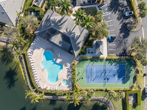 An aerial view of a resort with a swimming pool, tennis courts, and a parking area. - 2/2 Condo in Tortuga Preserve, Fort Myers! (Fort Myers)