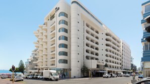 A modern hotel with multiple balconies and a prominent 'The Cole' sign. - Dolce Vita | Modern Sea Point Retreat (Cape Town)