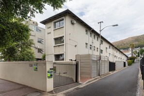 Ein mehrstöckiges Gebäude mit einem verschlossenen Eingang, einem Pflasterweg und einer Straßenlaterne.