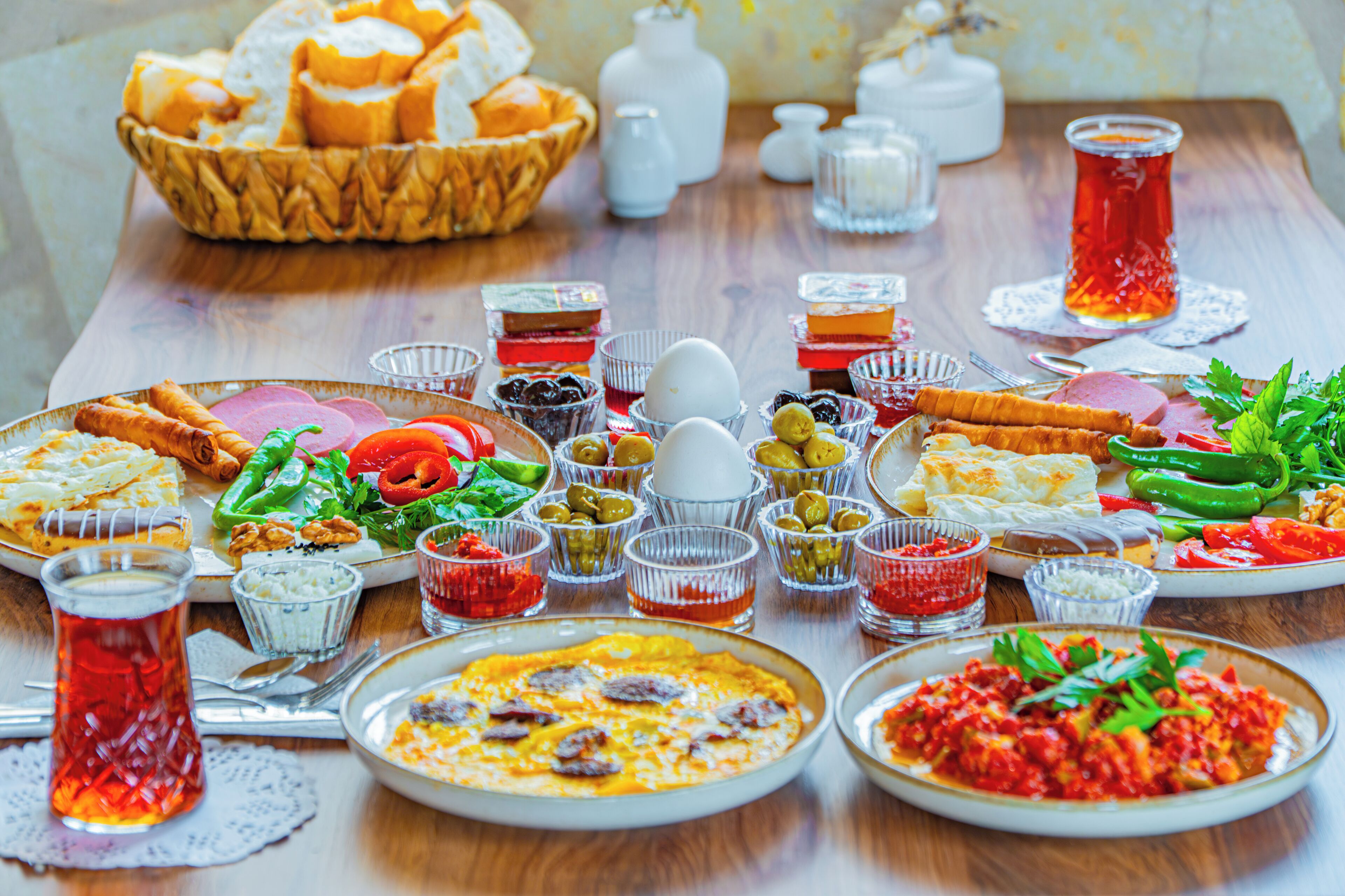 Uma mesa com diversos pratos, incluindo uma salada, pão e um prato de comida, sugerindo um ambiente de refeição.
