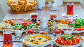 Uma mesa com diversos pratos, incluindo uma salada, pão e um prato de comida, sugerindo um ambiente de refeição.
