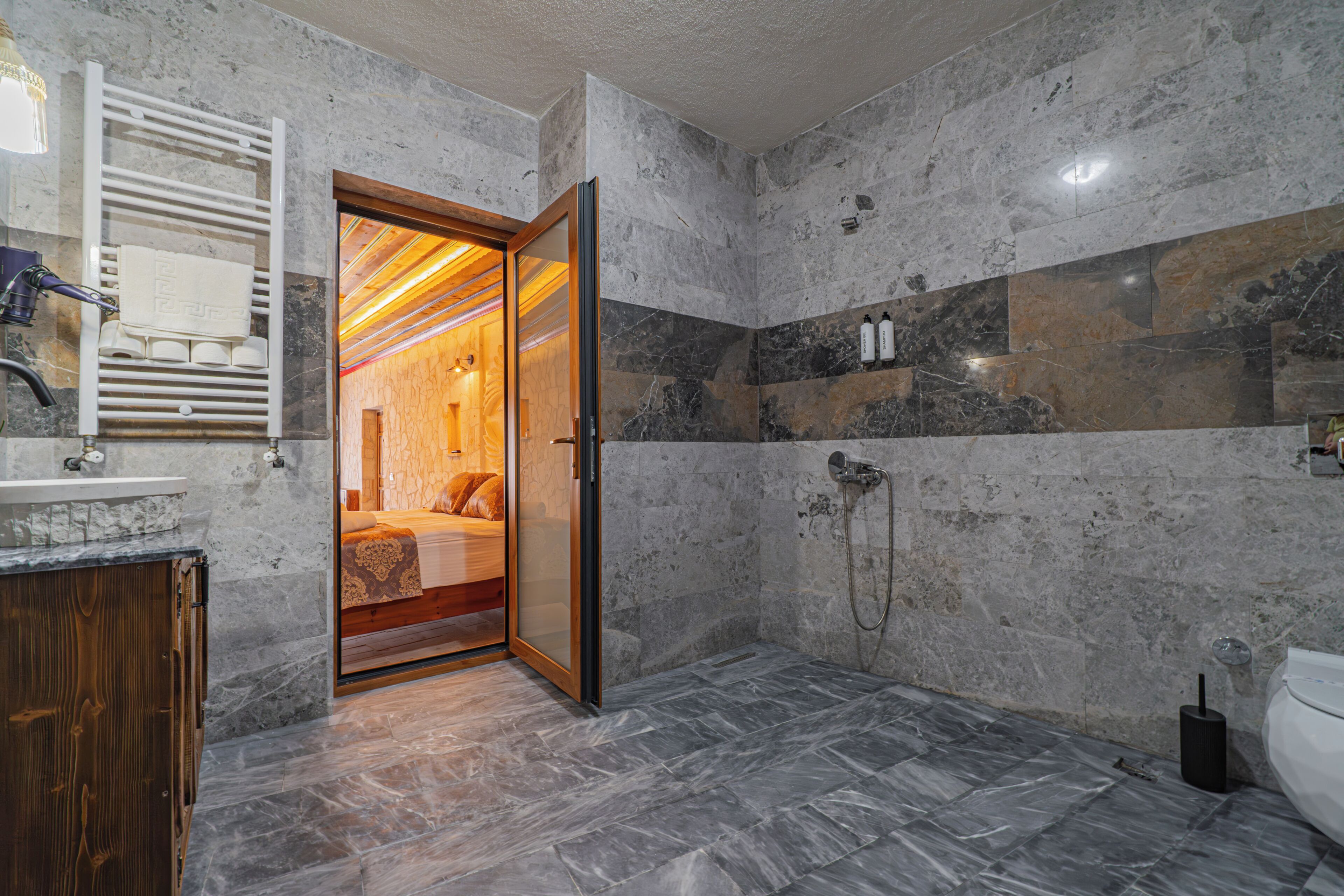 A bathroom with a shower, a toilet, a sink, and a mirror.