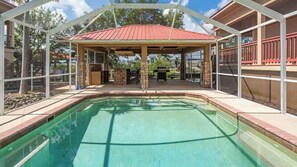 A swimming pool with a covered area, stone pillars, and a red roof. - Pirate's Cove (Punta Gorda)