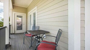A covered porch with a table and chairs, a door, and a window. - Pirate's Cove (Punta Gorda)
