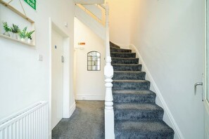 A staircase with a white balustrade leading to a landing. - Birkenhead CH43 | Spacious 6BR Home | Sleeps 12 (Birkenhead)