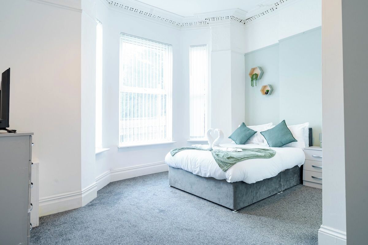 Un dormitorio con cama, cómoda y televisor.