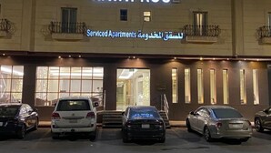 Un immeuble à plusieurs étages, sur lequel on peut lire les inscriptions « Hayat Rose » et « Appartements avec services ». Des voitures sont garées devant, et l’entrée est visible.