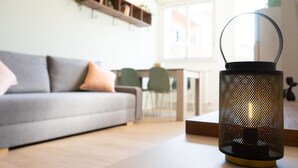 A modern living room with a sofa, a coffee table, and a decorative lantern. - Newly renovated apartment, located in the lively Bicocca area, right in front of the Arcimboldi Theatre, which offers shows and concerts throughout the year.The location is ideal: a stone's throw from the Greco train stop, from which you can reach the  (Milano)