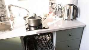 A kitchen with a dishwasher, a kettle, and a pot on the counter. - Newly renovated apartment, located in the lively Bicocca area, right in front of the Arcimboldi Theatre, which offers shows and concerts throughout the year.The location is ideal: a stone's throw from the Greco train stop, from which you can reach the  (Milano)
