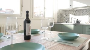 A dining table with a bottle of rosé wine, two wine glasses, and teal bowls. - Newly renovated apartment, located in the lively Bicocca area, right in front of the Arcimboldi Theatre, which offers shows and concerts throughout the year.The location is ideal: a stone's throw from the Greco train stop, from which you can reach the  (Milano)
