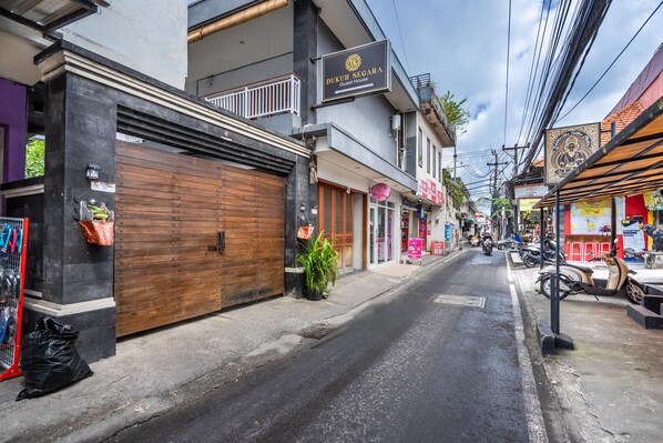 Une vue de rue avec un bâtiment portant l’inscription « Dukuh Segara Guest House ».