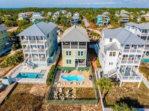 A multi-story residential building with a central pool, surrounded by a fence and deck. - Southern Charm (Port St. Joe)