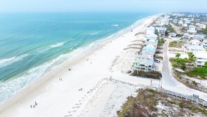 A coastal area with a beach, a road, and residential buildings. - West Wind (Port St. Joe)