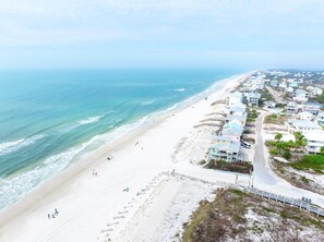 A coastal area with a beach, a road, and residential buildings. - West Wind (Port St. Joe)