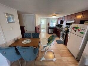 A compact kitchen with a dining area, a small refrigerator, and a microwave.