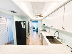 Eine Küche mit Kühlschrank, Herd, Mikrowelle und Spüle.