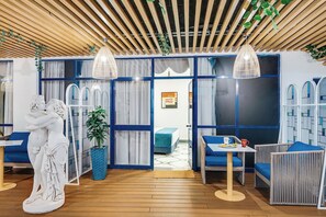 A modern interior with wooden slatted ceilings, a central statue, and blue and white decor.