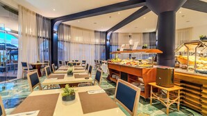Un espace de restauration d’hôtel avec des tables, des chaises et un buffet.