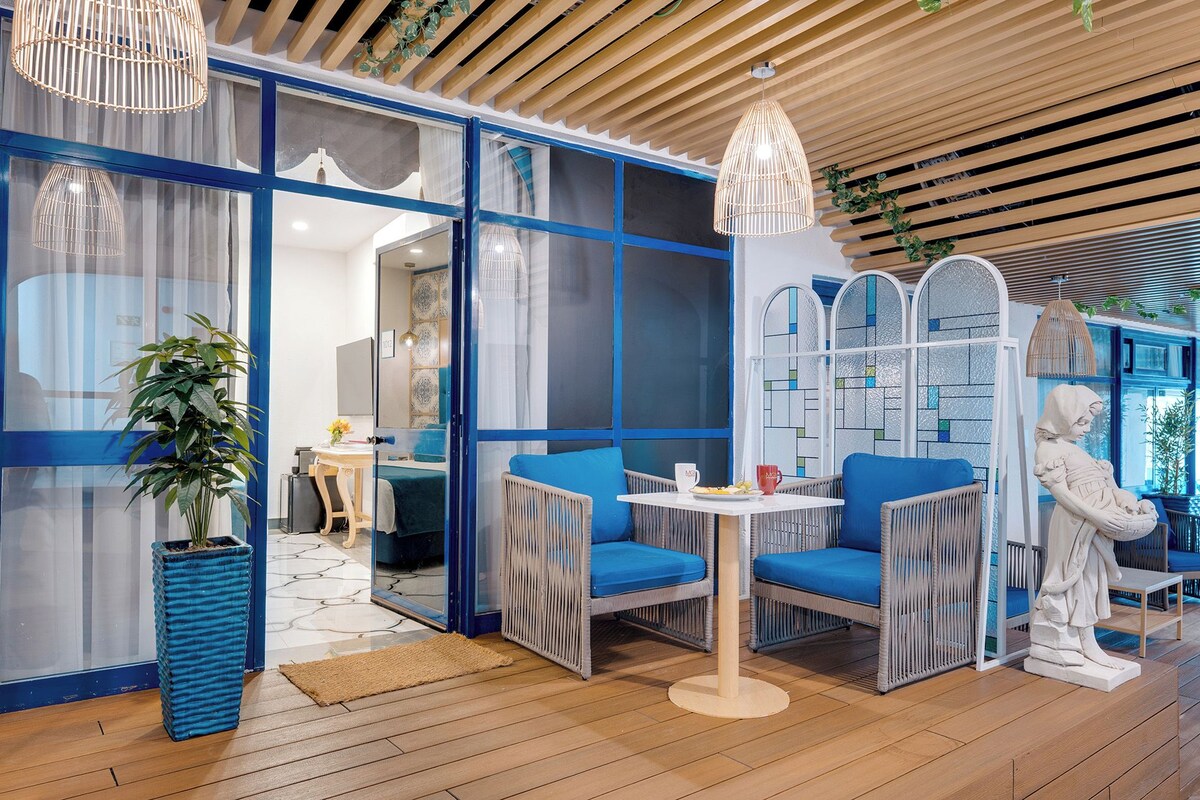 A modern interior with wicker furniture, a statue, and a blue and white color scheme.
