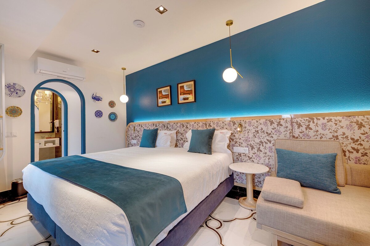 Un dormitorio moderno con una cama grande, un sofá y una mesita.