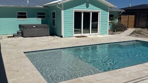 Une piscine avec une maison en arrière-plan.