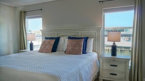 Una camera d'albergo con un letto grande, due comodini con lampade e vista su un ponte dalla finestra.