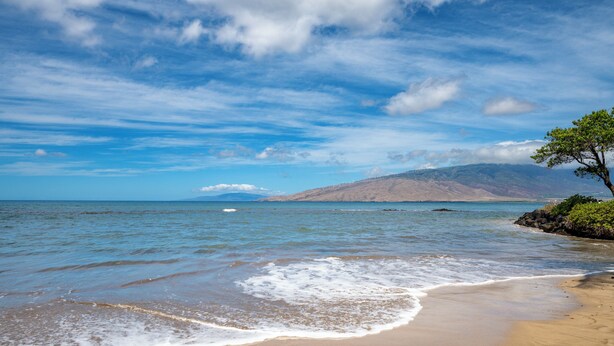 A beach with clear skies, gentle waves, and a distant mountain. - Kihei Bay Surf B212: Beachside Studio w/ Pool & Lanai (Kihei)