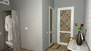 A bathroom with a shower, a towel rack, and a wooden floor. - Holiday Garden Tbilisi (Tbilisi)