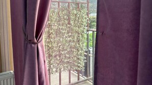 A balcony with a view of a tree and distant hills. - Holiday Garden Tbilisi (Tbilisi)