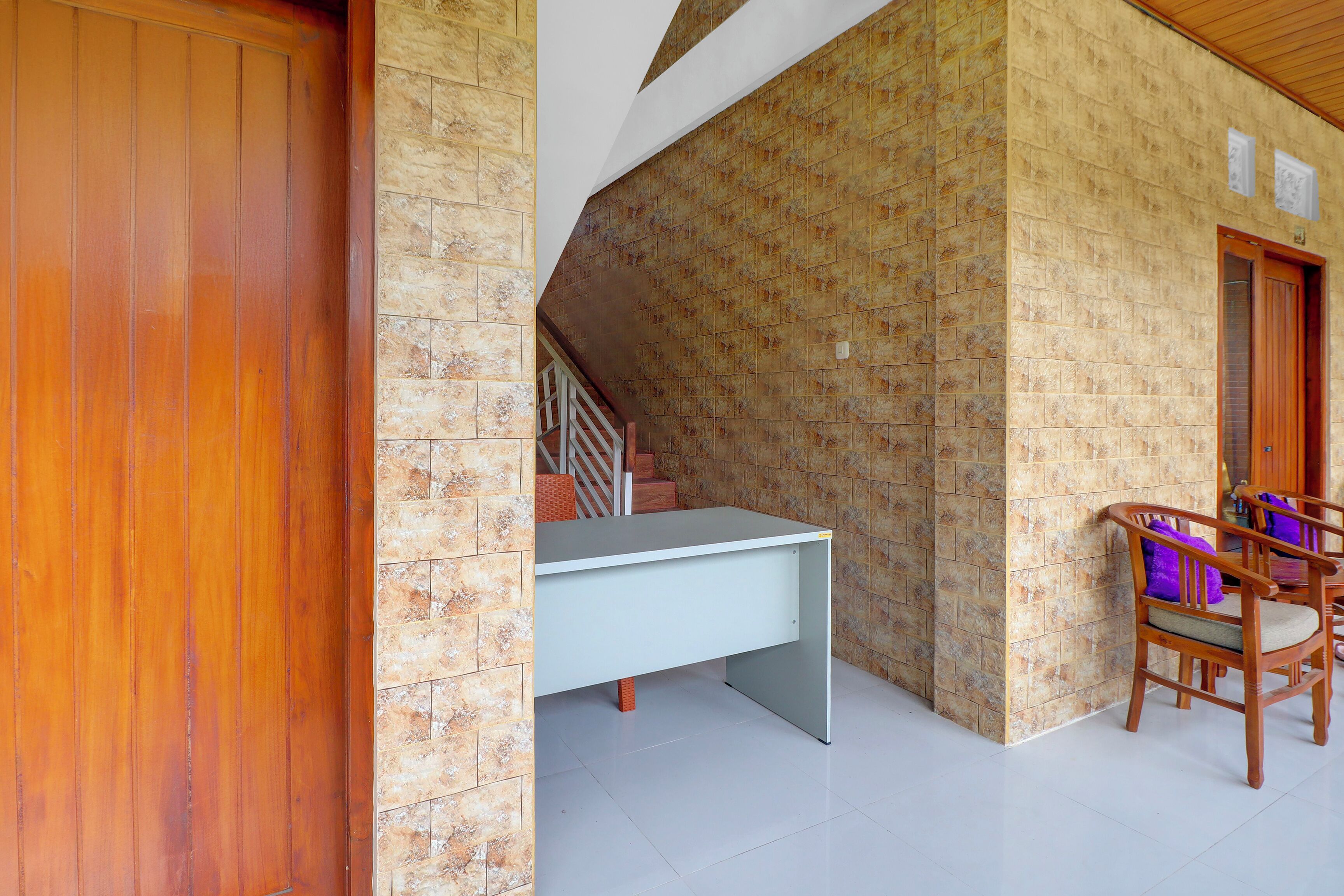 Una habitación con un escritorio, una silla, una puerta de madera y una escalera.