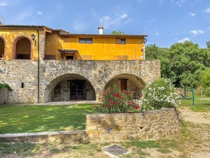Un edificio amarillo con arcos de piedra y una pared de piedra.