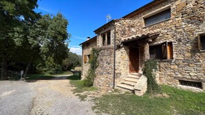 Un bâtiment en pierre avec une porte en bois, une fenêtre et un petit porche.