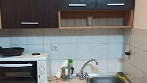 A compact kitchen with a microwave, sink, and cabinets. - Renovated Studio Heart of City (Thessaloniki)