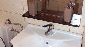 A bathroom with a white sink, a mirror, and a towel rack. - Renovated Studio Heart of City (Thessaloniki)