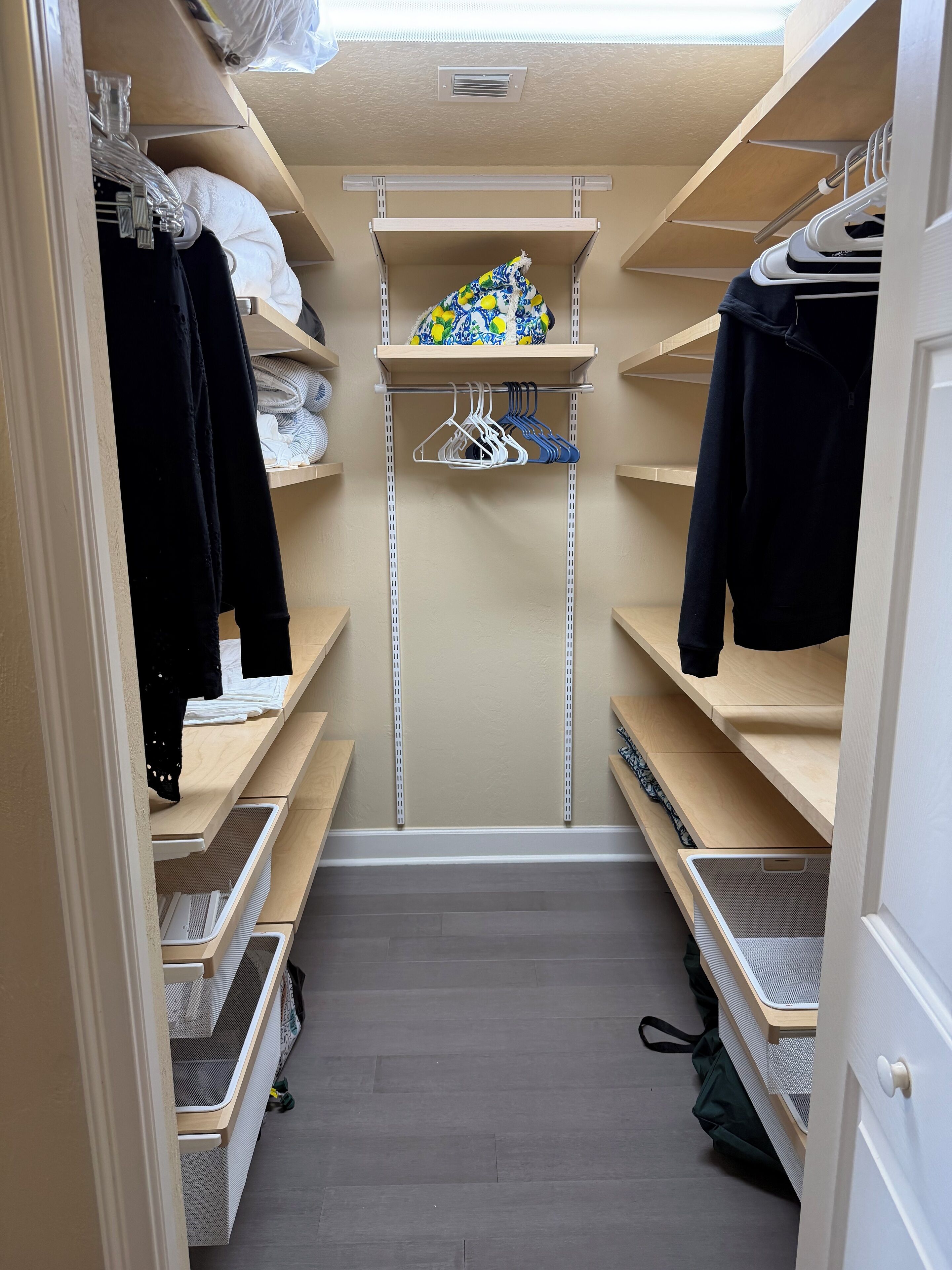 A walk-in closet with shelves, hanging space, and a shoe rack.